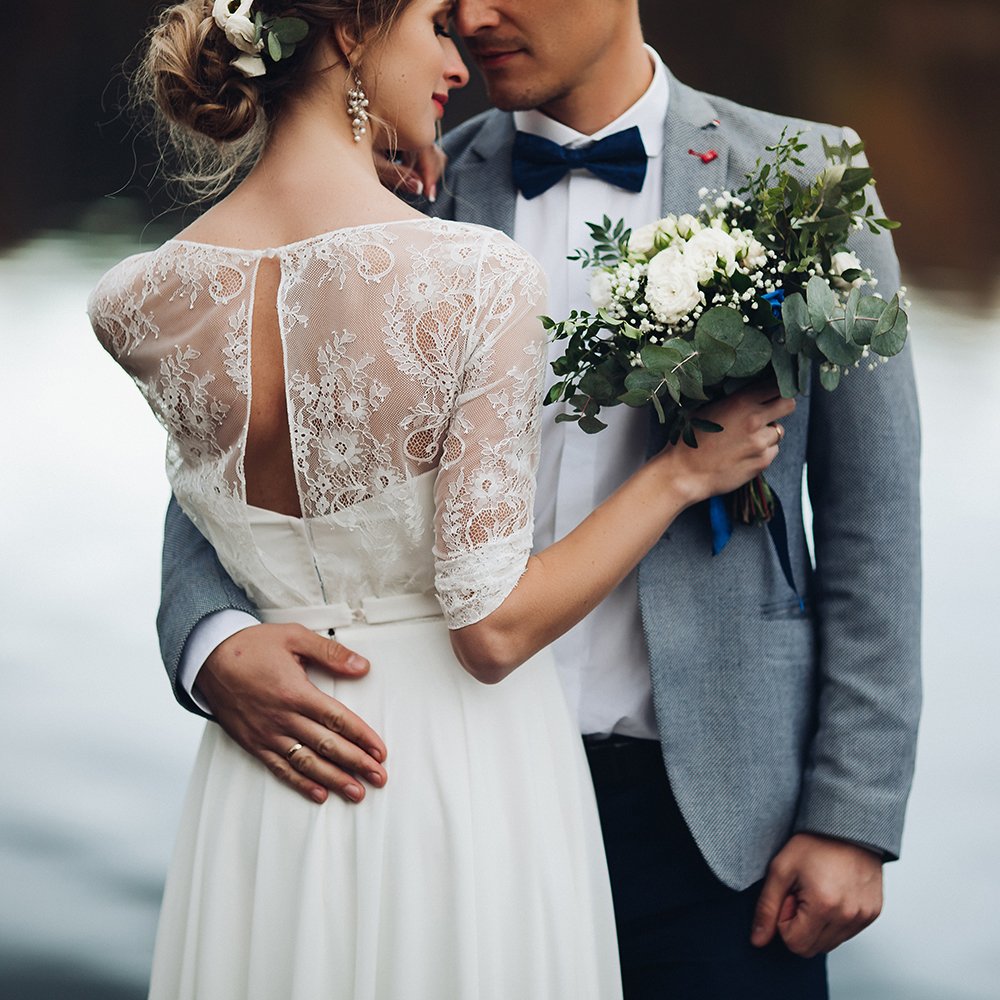 Crop of elegant newlywed against lake surface.